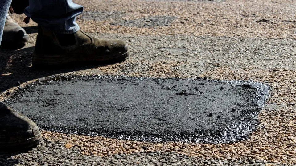 Full-depth patch cut square and filled with hot mix, compacted flush with the surrounding surface